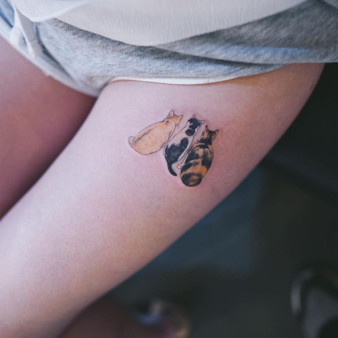 Minimalistic cats tattooed on the wrist.