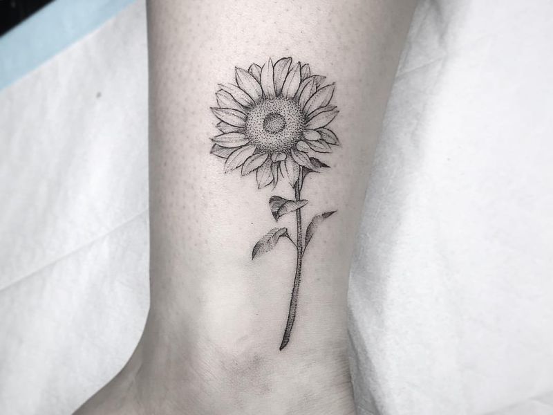 Minimalist sun and sunflower tattoo on the wrist