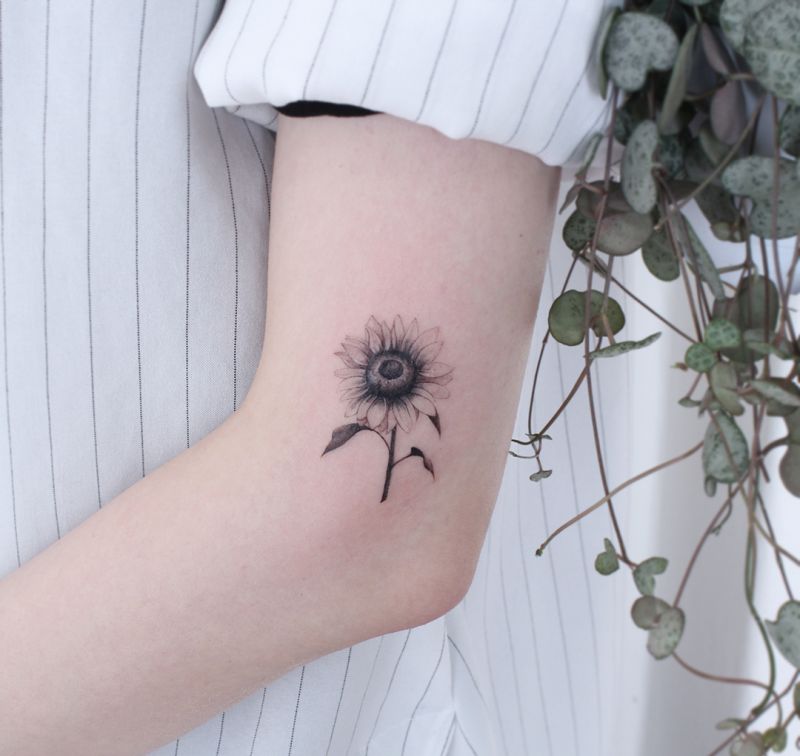 Minimalist sun and sunflower tattoo on the wrist